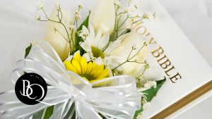 Bible Quotes for Weddings and Anniversaries - Flowers on Bible with the verse 'Above all, love each other deeply'