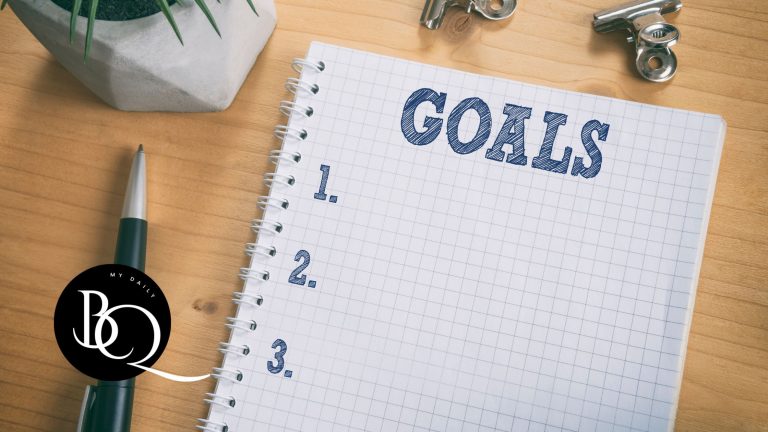 Notebook with 'Goals' written at the top beside a Bible and pen